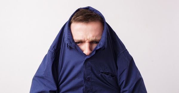 Man with head stuck in blue collared shirt
