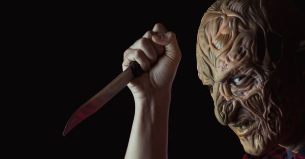 person with horror mask and bloody knife