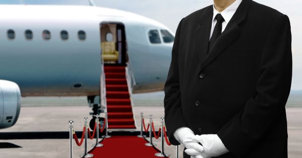 Man in suit waiting in front of a private jet