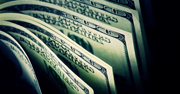 $100 US Dollar bills in dark background