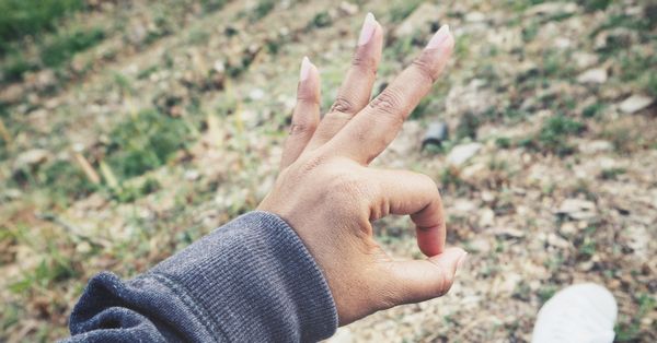 Hand of person making the "A-OK" or finger circle sign.