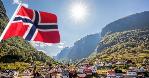 View of small fishing town with Norwegian Flag in foreground