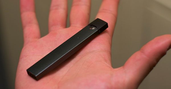 JUUL e-cigarette in the palm of someone's hand.