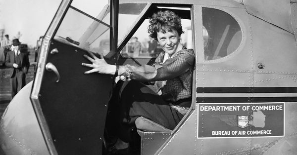 Amelia Earhart smiling from her cockpit.
