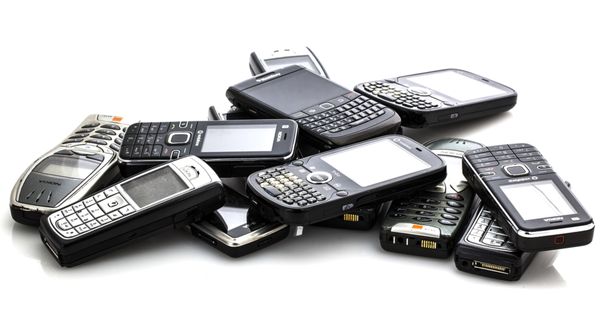 A pile of old mobile phones against a white background.