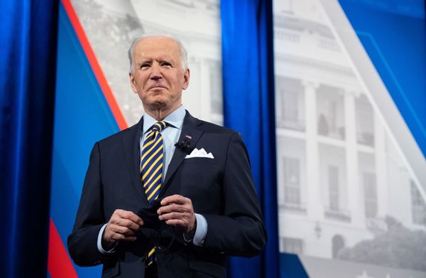US President Joe Biden holds a face mask