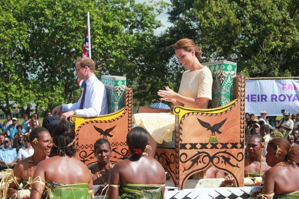 Prince William and Kate are carried on portable thrones or litters.