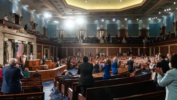 A photograph allegedly shows a demon stranding in the back of the room during President Biden's joint address to congress.