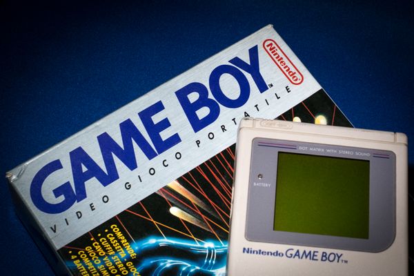A photo shows Hillary Clinton playing a Game Boy on a flight while seated on an airplane.