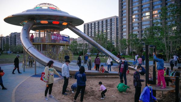 Children play on UFO-shaped slide in China.