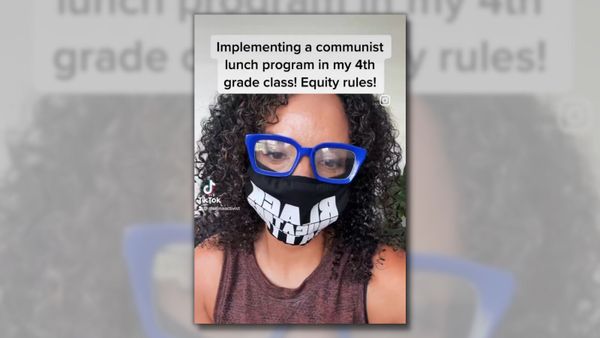A Black woman wearing a black mask and blue glasses is facing a camera. Towards the top of the screen, black text says "Implementing a communist lunch program in my 4th grade class! Equity rules!"