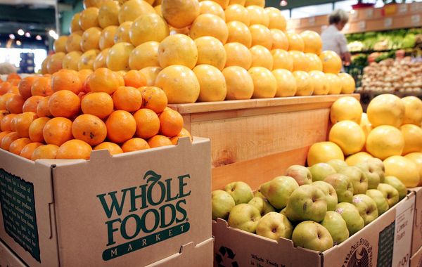 Fruit including melons and oranges is stacked in a Whole Foods Market.