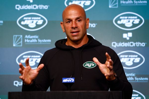 A Lebanese man wearing a black hoodie with a New York Jets patch on it stands at a podium.