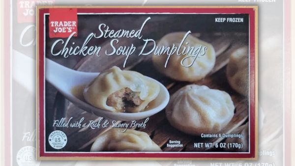 A package states that it contains Trader Joe's Steamed Chicken Soup Dumplings Filled with a Rich and Savory Broth. Several balls of dough containing meat and other fillings are shown.