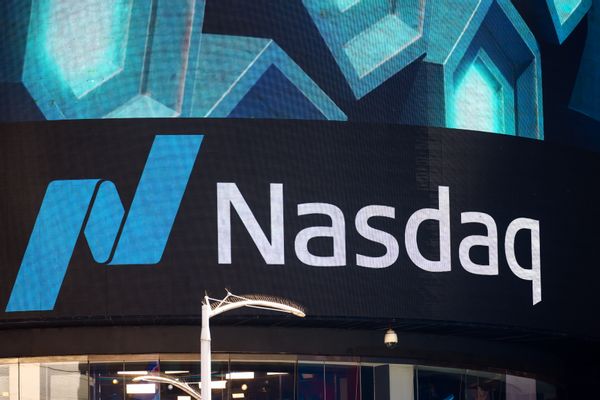A white sign says Nasdaq to the left of a blue N sign.