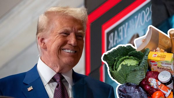 A close up of Donald Trump, a white man with an orange-toned tan, in a suit smiling. A white outline graphic of some groceries in the bottom right hand corner of the image. 