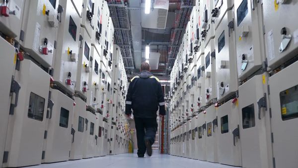 A person walks down a hall full of switches.