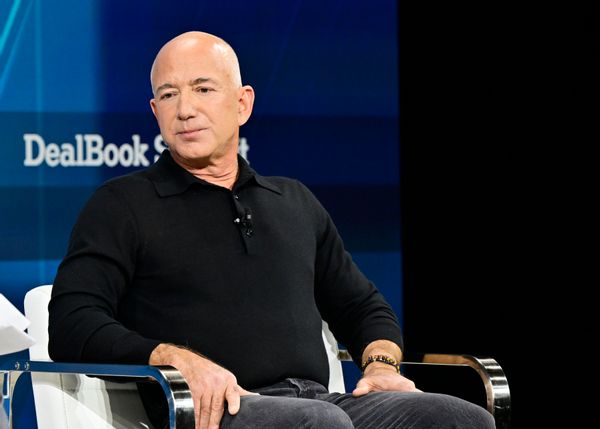 A white man sits in a chair.