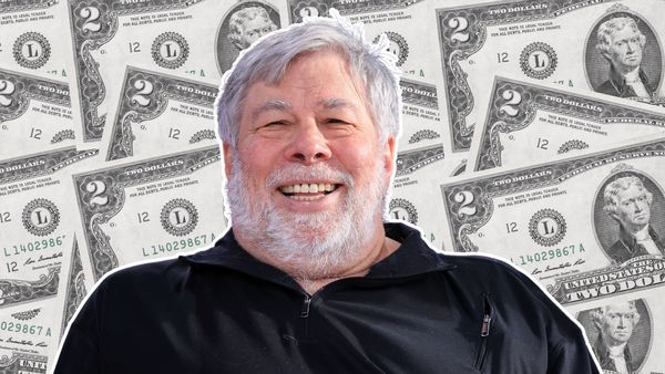 A white man wearing a black shirt is pictured in front of many $2 bills.