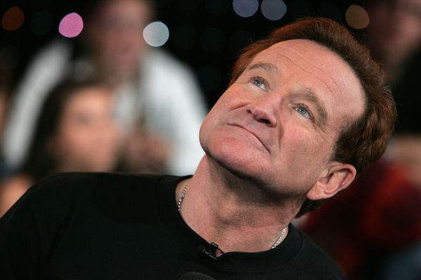 A clean-shaven white man with a square face and short brown hair looks upward. 