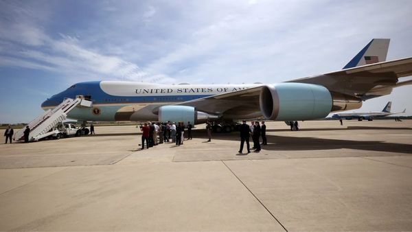A large plane is shown that says UNITED STATES OF AMERICA. People stand around it.