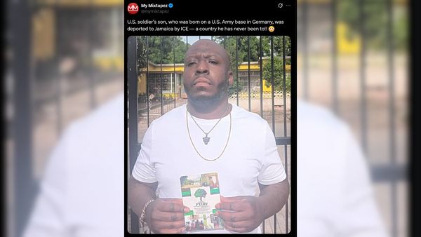 A man with a shaved head and beard stands outside holding a booklet, wearing a white t-shirt, gold chain, and pendant. Behind him is a black metal fence and yellow building. Text of the X post above reads: “U.S. soldier’s son, who was born on a U.S. Army base in Germany, was deported to Jamaica by ICE — a country he has never been to!!”