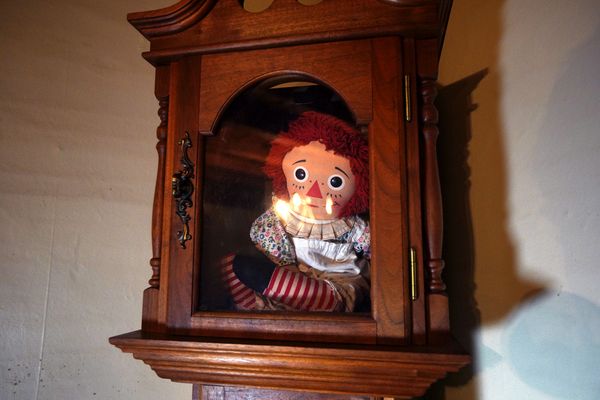 Raggedy Ann doll known as Annabelle is shown encased in glass box. 