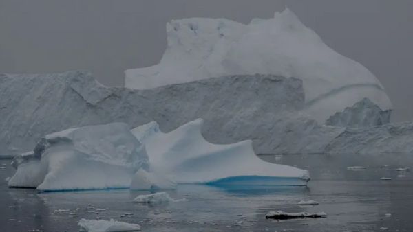 Large ice blocks are seen on top of water that is frozen over.