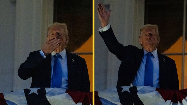 A white man is shown standing on a balcony. On the left, he puts a hand over his mouth like he is about to blow a kiss while on the right he holds his right hand up like he is waving.