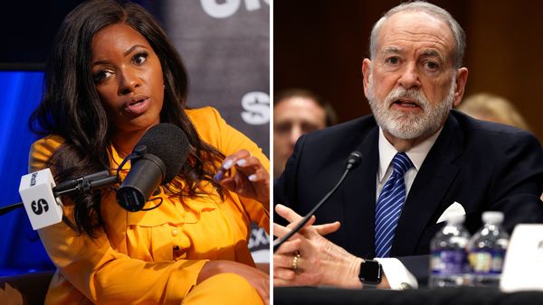 A Black woman is pictured next to a white man. Both are speaking into microphones.