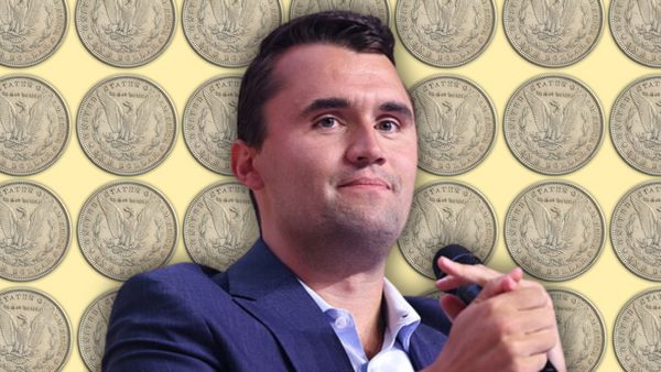Charlie Kirk, a white man with short brown hair wearing a suit, in front of a repeated background pattern of one dollar U.S. coins. 