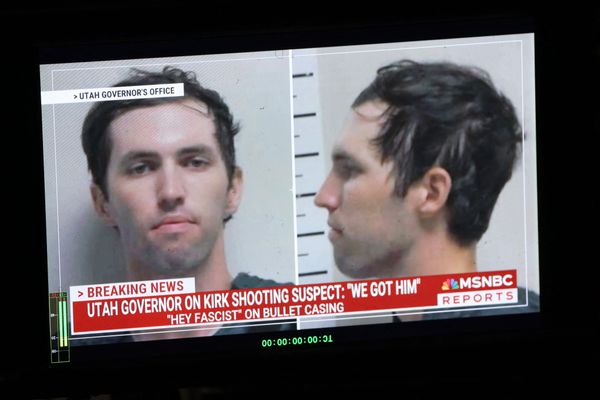 A mugshot of a young white man with short brown hair is shown on a TV news broadcast. 