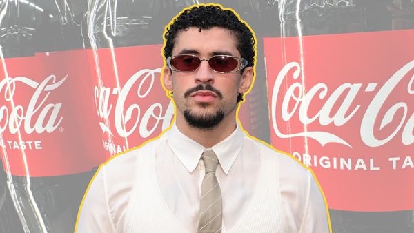 A Latino is pictured in front of large Coca-Cola jugs of soda.