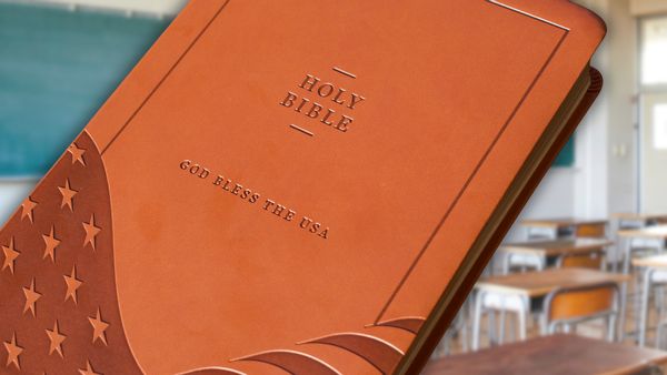 In this photo collage, a brown leather-bound "God Bless the USA" Bible takes up the majority of the image. In the background, there is a stock image of an empty classroom.