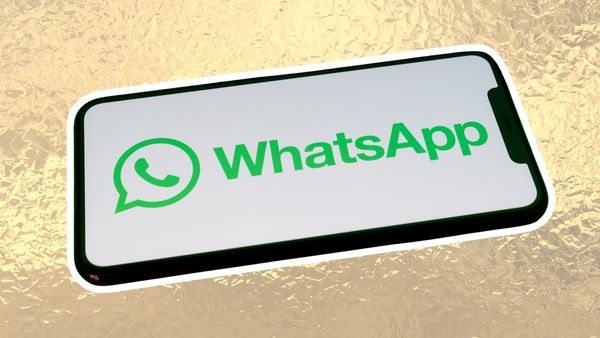 WhatsApp logo on phone with white background on top of a foiled gold background