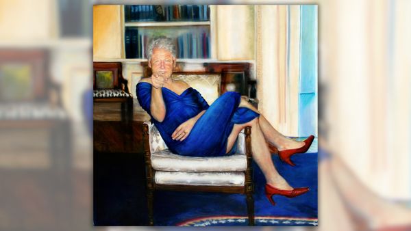 A portrait of U.S. President Bill Clinton sitting cross-legged in a chair, wearing a blue dress and pointing at the viewer. 