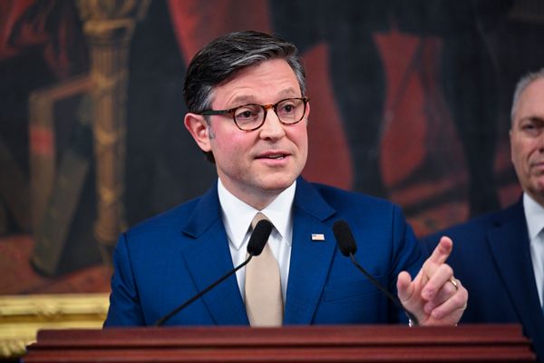 U.S. Speaker of the House Mike Johnson, a white man wearing a suit with short hair and glasses, stands behind the podium. 