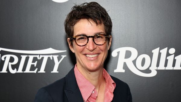 A white woman is shown smiling at the camera. 