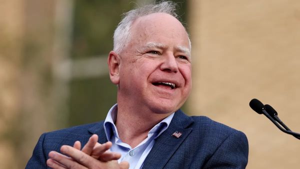 Minnesota Gov. Tim Walz, a balding white man with a ruddy complexion in a suit. 