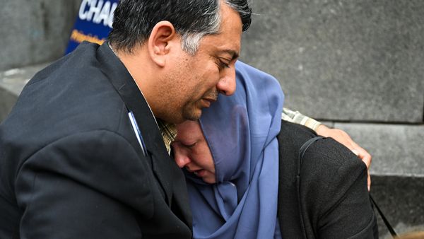 Muhammad Zahid Chaudry, a U.S. Army veteran originally from Pakistan, hugs his wife, Melissa Chaudry, and cries during a memorial.