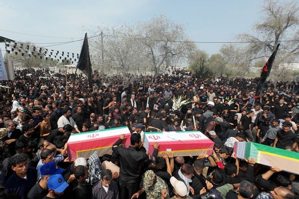 Large crowd gathers in Iran and holds coffins featuring Iranian flag to mourn children killed in Minab girls' school missile strikes.