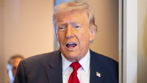 U.S. President Donald Trump stands in an airplane and talks. 