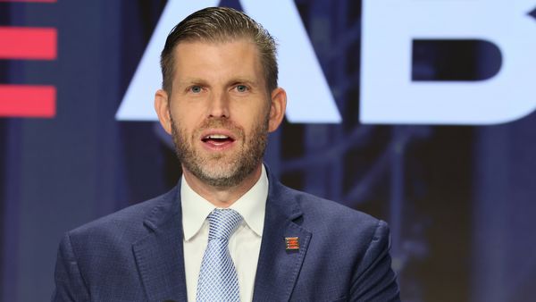 Image shows Eric Trump, a white man, giving a speech.