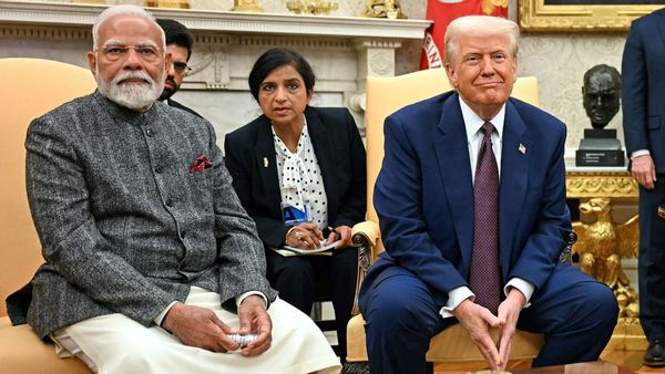 Narendra Modi, an Indian man with white hair, mustache and beard, sits next to Donald Trump, a white man with tan skin and white-blond hair.