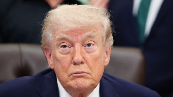 The image shows U.S. President Donald Trump sitting in the Oval Office.