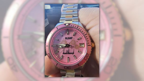 A gold and silver watch with a pink watch face reads "RUMP" instead of "TRUMP."