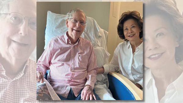 Photo shows Mitch McConnell, an elderly white man, wearing a checkered shirt while in a hospital bed. His wife, Elaine Chao, is photographed next to him.