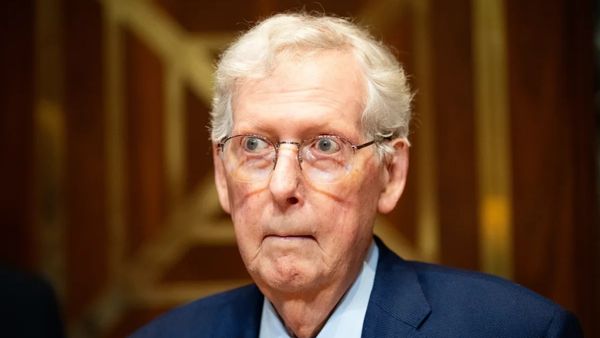 Mitch McConnell, a white man wearing a blue suit, stares forward.