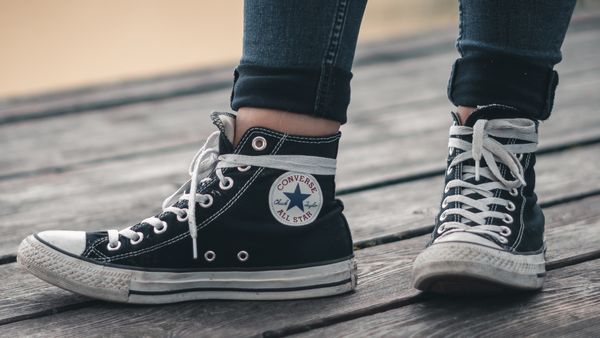 Close-up shot of a pair of black Converse high-top shoes. 