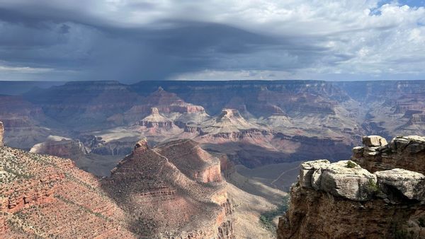 A photo shows a wide daytime view of the Grand Canyon from far above.